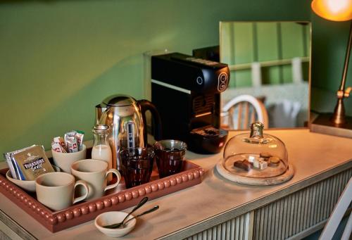 a counter top with cups and coffee cups on it at The White Horse - A Heartwood Inn in Dorking