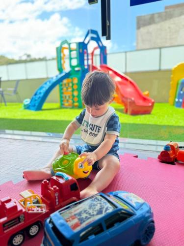 a young boy playing with toy cars and a toy truck at Panorama Hotel in Águas de Lindóia