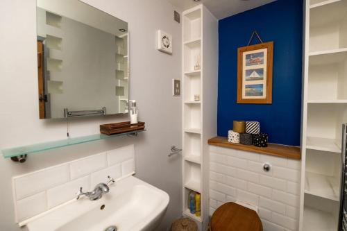 La salle de bains est pourvue d'un lavabo et d'un miroir. dans l'établissement Charming, coastal guest house, à Clanfield