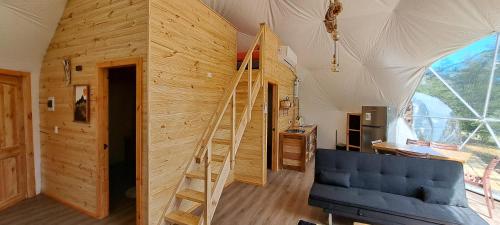 a living room with a staircase in a wooden house at Cabaña y Domos El Pescador Coyhaique in El Blanco