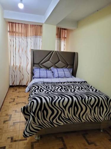 a bedroom with a zebra print bed with purple pillows at Apartamento en Huancayo in Huancayo