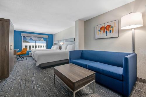 une chambre d'hôtel avec un lit et un canapé bleu dans l'établissement Holiday Inn Express San Diego - Sorrento Valley, an IHG Hotel, à Sorrento