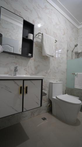 Baño blanco con aseo y lavamanos en Villa Sol Taino, Hotel en Boca chica, 5 minutos del Aeropuerto Internacional las Américas, en La Golondrina