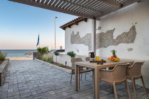 une terrasse avec une table et des chaises et l'océan dans l'établissement Bluetique Seaside Suites, à Gra Liyiá