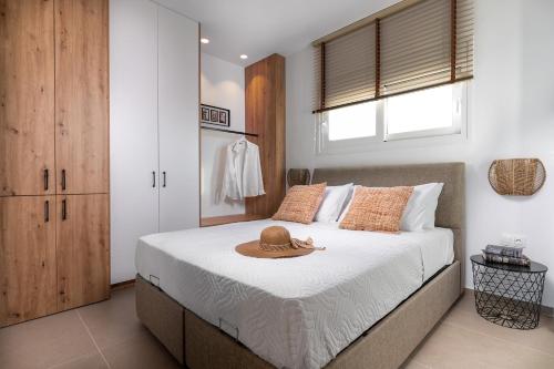 - une chambre avec un lit doté d'un chapeau dans l'établissement Bluetique Seaside Suites, à Gra Liyiá