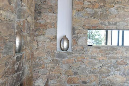 un mur de pierre avec un miroir et une fenêtre dans l'établissement Villa 6 chambres, vue mer sur 180°,plage privée., à Cavalaire-sur-Mer