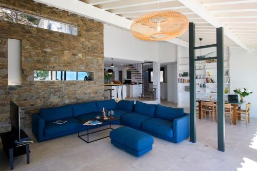 - un salon avec un canapé bleu et un mur en briques dans l'établissement Villa 6 chambres, vue mer sur 180°,plage privée., à Cavalaire-sur-Mer