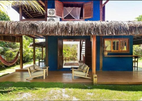 uma casa com duas cadeiras e um telhado de palha em Casa Bora Lá em Caraíva