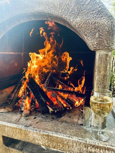 a fire in a grill with a glass of wine at Kuća za odmor Vrdnik in Vrdnik