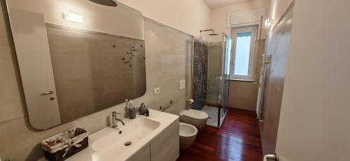 a bathroom with a sink and a toilet and a mirror at Casa Di Ariel in La Spezia
