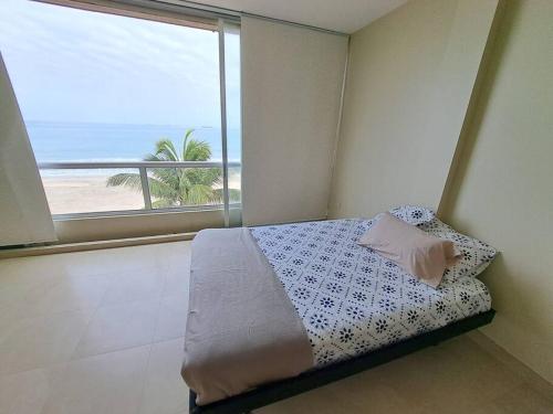 um quarto com uma cama e vista para o oceano em Departamento con hermosa vista frente al mar cerca de Puntablanca em La Libertad