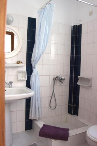 a bathroom with a shower and a sink at Villas Georgy in Parikia