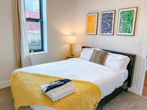 ein Schlafzimmer mit einem großen Bett und einer gelben Decke in der Unterkunft McCormick Place homie 3Br/2Ba with optional Parking for up to 6 guests in Chicago