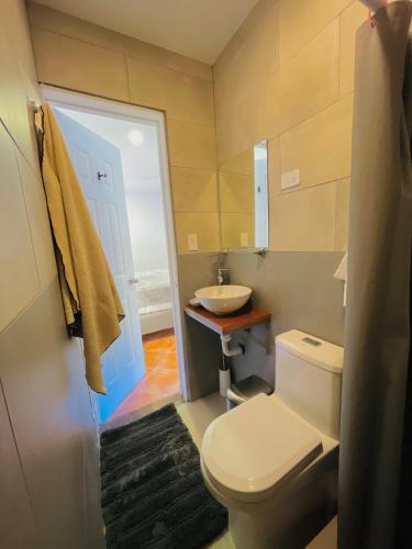 a bathroom with a white toilet and a sink at Spinoza Hotel Los Pargos Playa Negra in Playa Negra