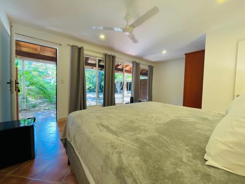 a bedroom with a large bed and a large window at Private Room Playa Negra in Playa Negra