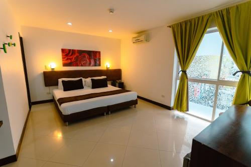 a bedroom with a bed and a large window at Hotel Boutique las Rosas 5 G in Medellín