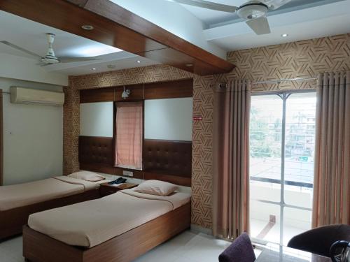 Duas camas num quarto com uma janela em Hotel Red Roof Inn em Comilla