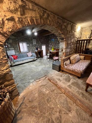 Habitación de piedra con 2 camas y pared de piedra. en I Ruderi di Maiano, en Vaglia