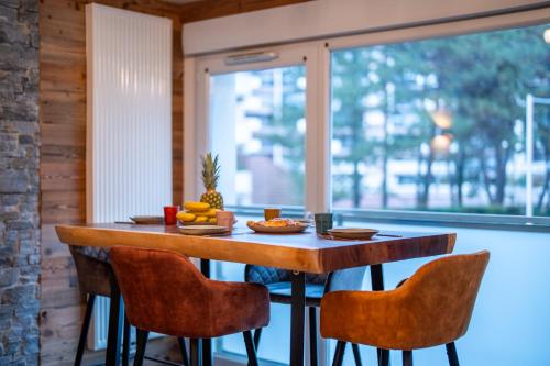 a wooden table with chairs and fruit on it at Charmant appartement à 5 minutes à pied de la vielle ville Annecy avec parking privé in Annecy