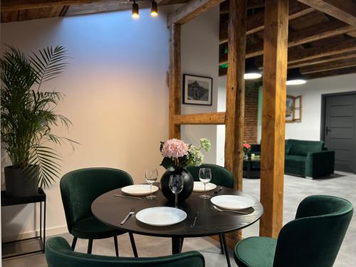een eetkamer met een tafel en groene stoelen bij Parkcity Katowice Bogucice in Katowice