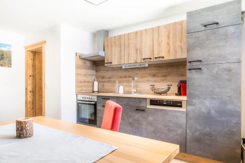 a kitchen with wooden cabinets and a wooden table with a wooden table at Biobauernhof Tonimörtl in Mariapfarr