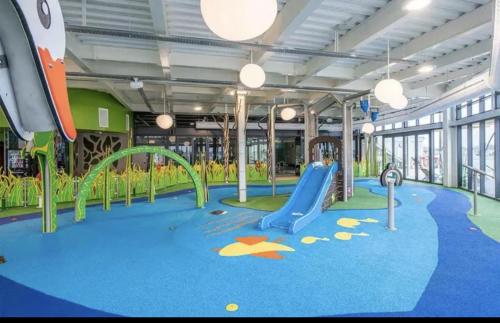 a childrens play area with a slide and swings at Home from Home Lettings at Tattershall Lakes - The Green in Tattershall