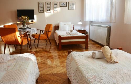 um quarto com 2 camas, uma secretária e uma mesa em Sobe Gajić Sremski Karlovci em Sremski Karlovci