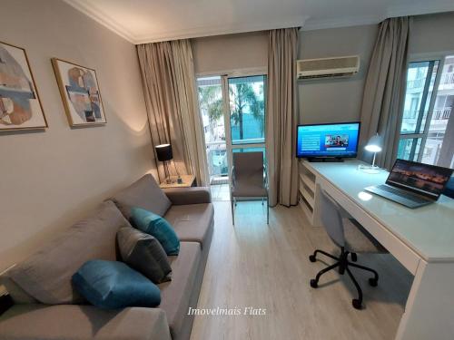 a living room with a couch and a desk with a laptop at Executive Perdizes Tower in Sao Paulo