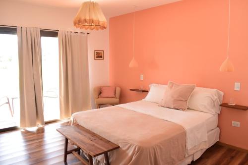 a bedroom with a large bed and a chair at Villa Mendotza in Ciudad Lujan de Cuyo