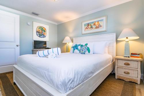 1 dormitorio con 1 cama blanca grande y 2 lámparas en The Tiki House, en Holmes Beach