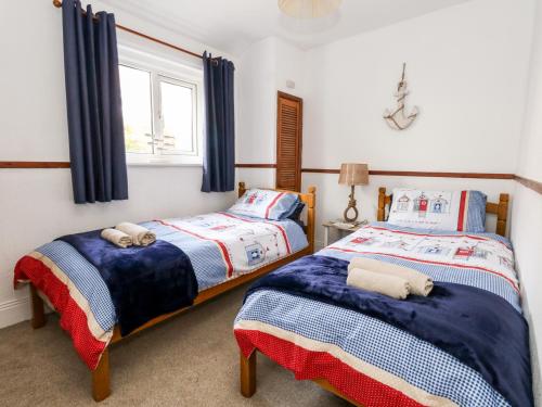 um quarto com 2 camas e uma janela em Saddlers Cottage em Weymouth