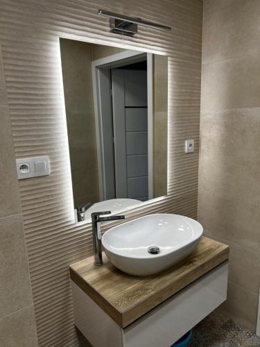 a bathroom with a sink and a mirror at Apartament 4You in Żywiec