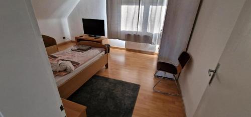 ein kleines Schlafzimmer mit einem Bett und einem TV in der Unterkunft Rooms & Apartments Schwäbisch Gmünd in Schwäbisch Gmünd