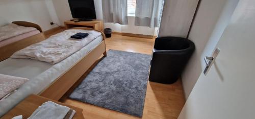 a room with two beds and a blue rug at Rooms & Apartments Schwäbisch Gmünd in Schwäbisch Gmünd