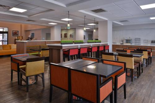 a restaurant with tables and chairs and a bar at Holiday Inn Express & Suites Austin North Central by IHG in Austin