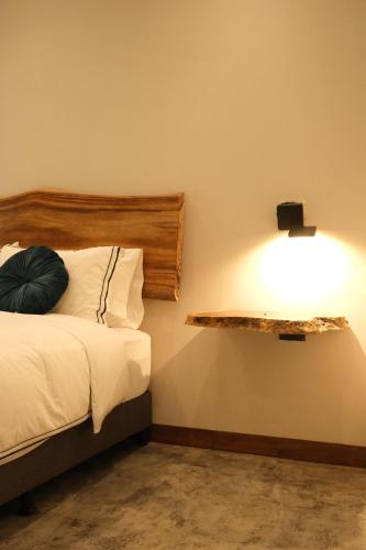 a bedroom with a bed and a light on the wall at UKO Urban Ekolodge in Armenia