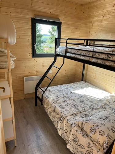 une chambre avec deux lits superposés et une fenêtre dans l'établissement Le petit Levant, à Saint-Pal-de-Mons