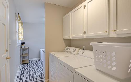 lavadero con armarios blancos y lavadora y secadora en Winston Salem's Sunshine Villa, en Winston-Salem