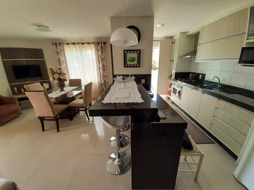 cocina con mesa en el centro de una habitación en Apartamento praia Bombas com 2 quartos cobertura, en Bombinhas