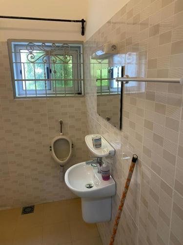 uma casa de banho com um lavatório e um espelho em Villadeluxe1 em Cotonou