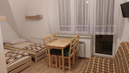a small room with a table and chairs and a bed at Dom Wczasowy Skałka in Żabnica