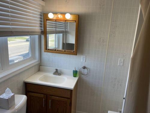 ein Badezimmer mit einem Waschbecken, einem Spiegel und einem WC in der Unterkunft 1 Bedroom, 1 Bath, Ranch Style 