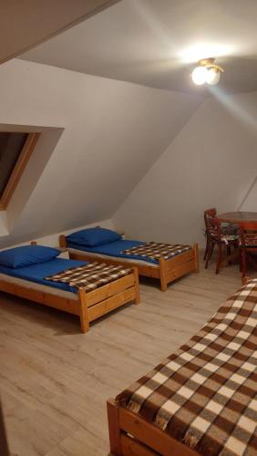 a attic room with three beds and a table at Dom Wczasowy Skałka in Żabnica