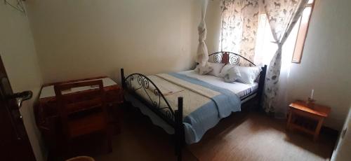 1 dormitorio con cama y ventana en SAWA SAWA GUEST HOUSE en Kisoro