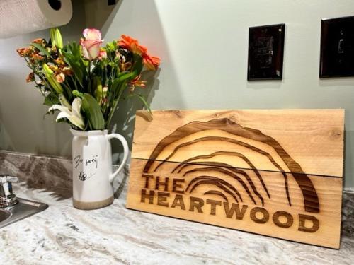 ein Holzschild mit einer Vase Blumen auf der Theke in der Unterkunft The Heartwood in Hamden