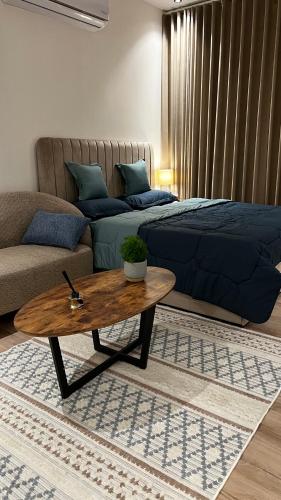 un salon avec un lit et une table basse dans l'établissement استديو أنيق, à Riyad