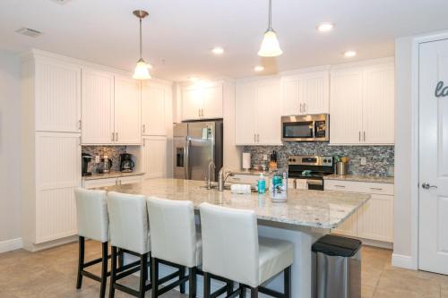a kitchen with a large island with white cabinets at One Particular Harbour 379-101 in Bradenton