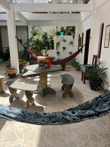 a patio with a hammock and tables and plants at Pousada Betel - Moradas Familia Betel in Salvador