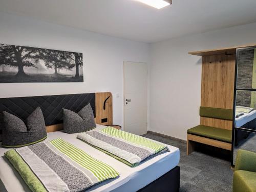 1 dormitorio con 1 cama y 1 silla en Pension Am Waldrand en Mosbach