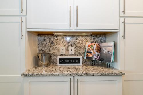 a kitchen with white cabinets and a counter top at One Particular Harbour Sound View 379-401 in Bradenton